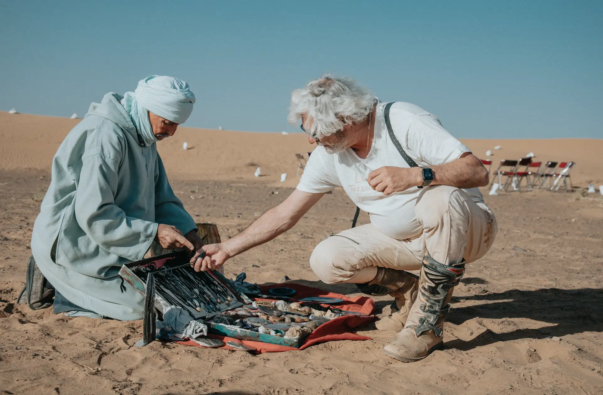 Lokaler Berber-Guide zeigt einem Reisenden Wüstenfossilien und Mineralien in der Sahara